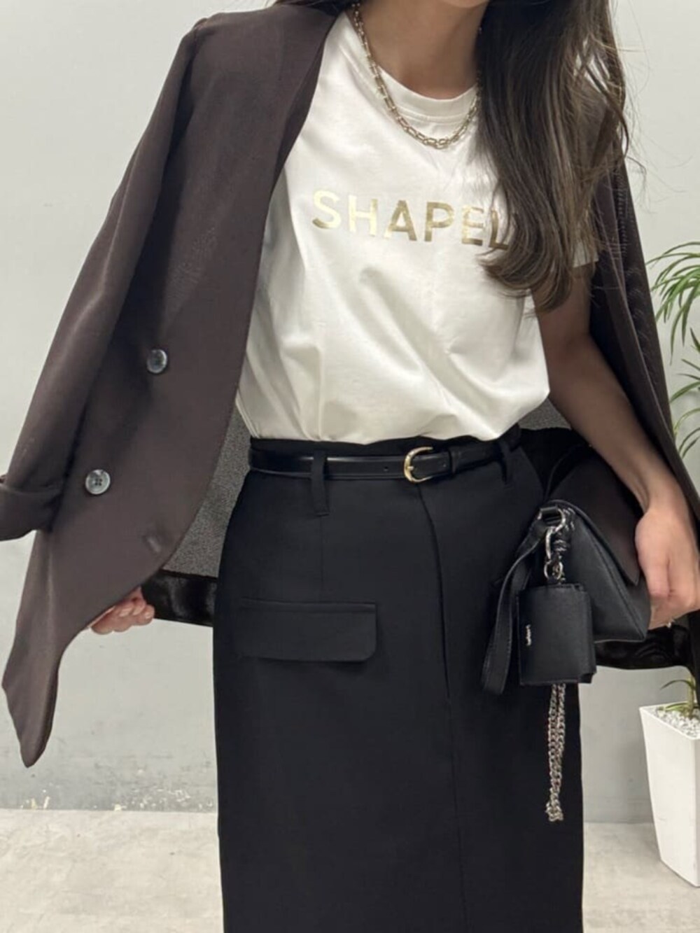 ブラック系のショルダーバッグ、ホワイト系のTシャツ/カットソーを着用したレディースの春コーディネートの3枚目の写真