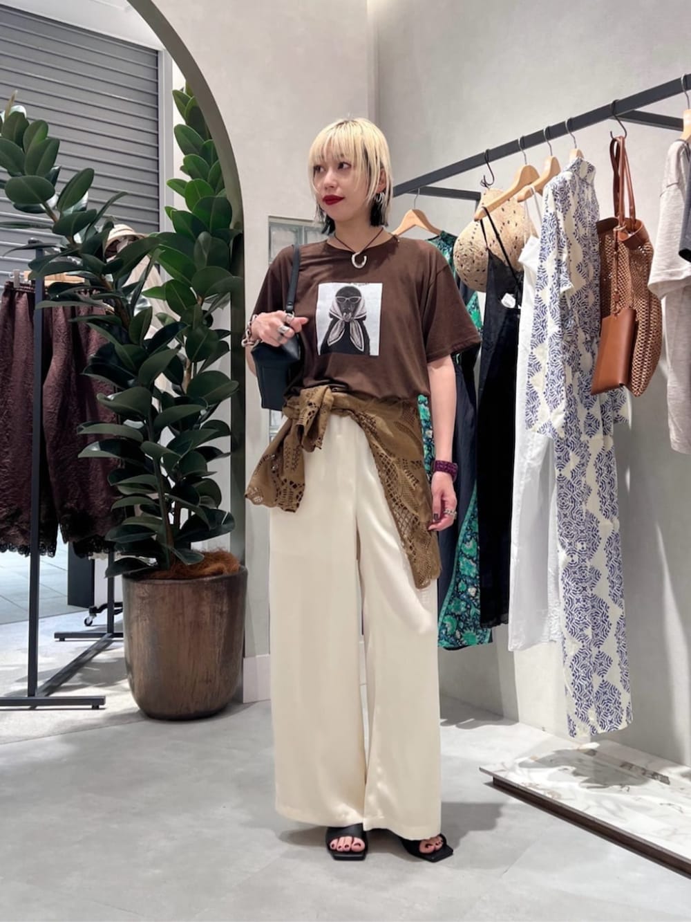 ブラック系のショルダーバッグ、ブラウン系のシャツ/ブラウス、ブラウン系のTシャツ/カットソーを着用したレディースの夏コーディネートの3枚目の写真