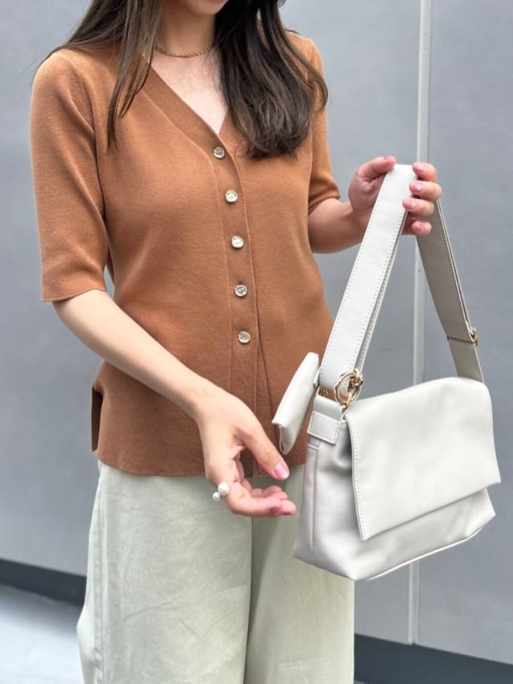 ベージュ系のその他パンツ、ホワイト系のショルダーバッグ、イエロー系のカーディガン/ボレロを着用したレディースの夏コーディネートの2枚目の写真
