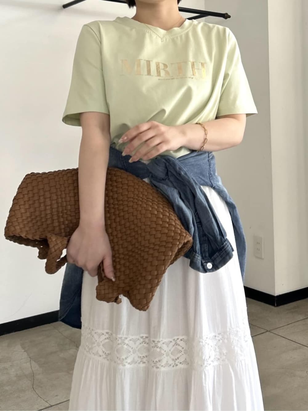 ホワイト系のスカート、グリーン系のTシャツ/カットソー、ブルー系のシャツ/ブラウスを着用したレディースの春コーディネートの2枚目の写真