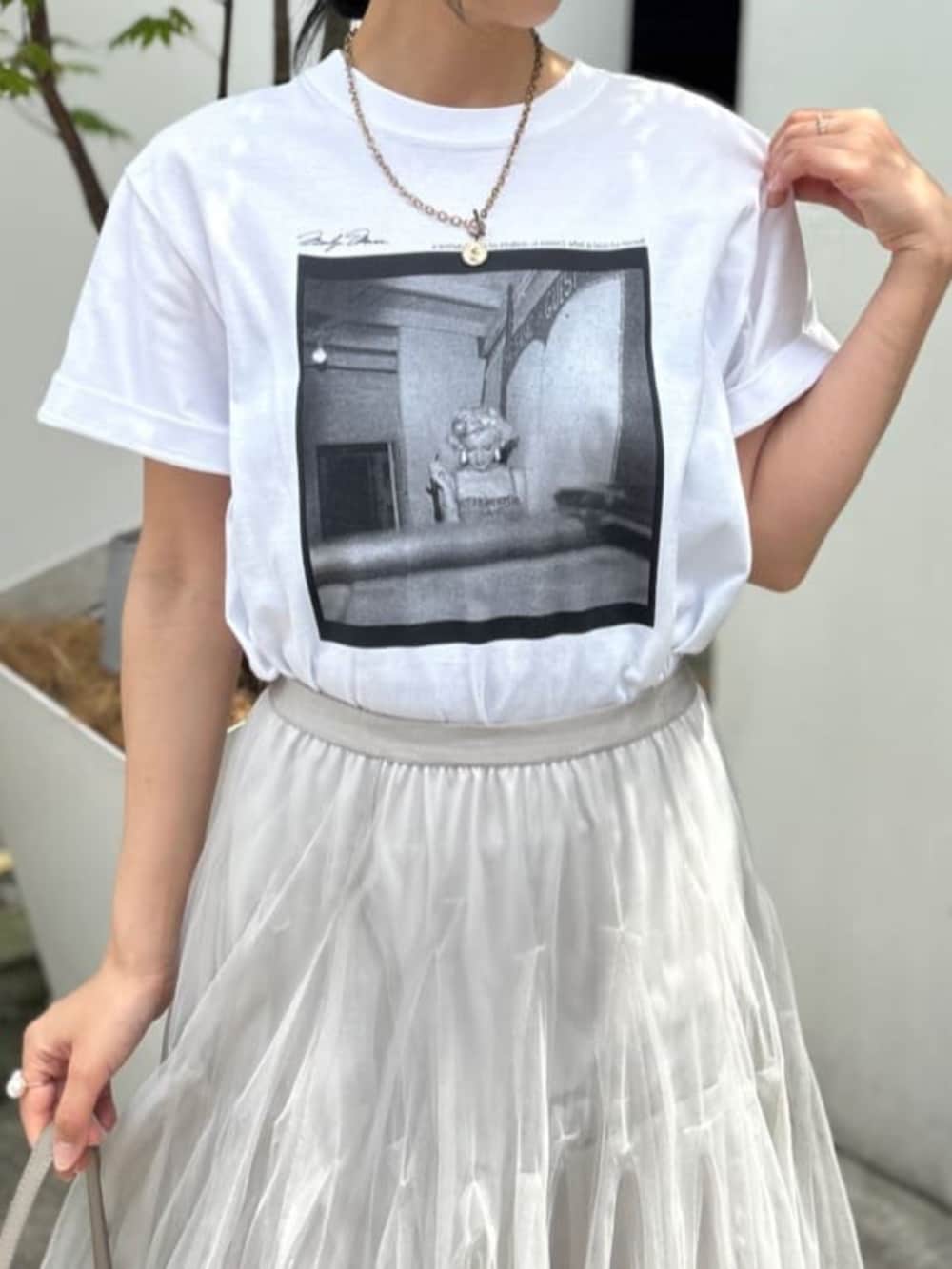ベージュ系のショルダーバッグ、ホワイト系のTシャツ/カットソー、ベージュ系のスカートを着用したレディースの夏コーディネートの2枚目の写真