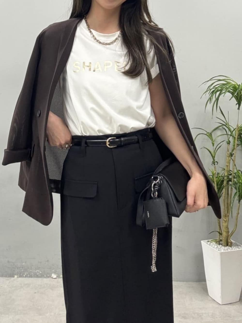 ブラック系のショルダーバッグ、ホワイト系のTシャツ/カットソーを着用したレディースの春コーディネートの2枚目の写真