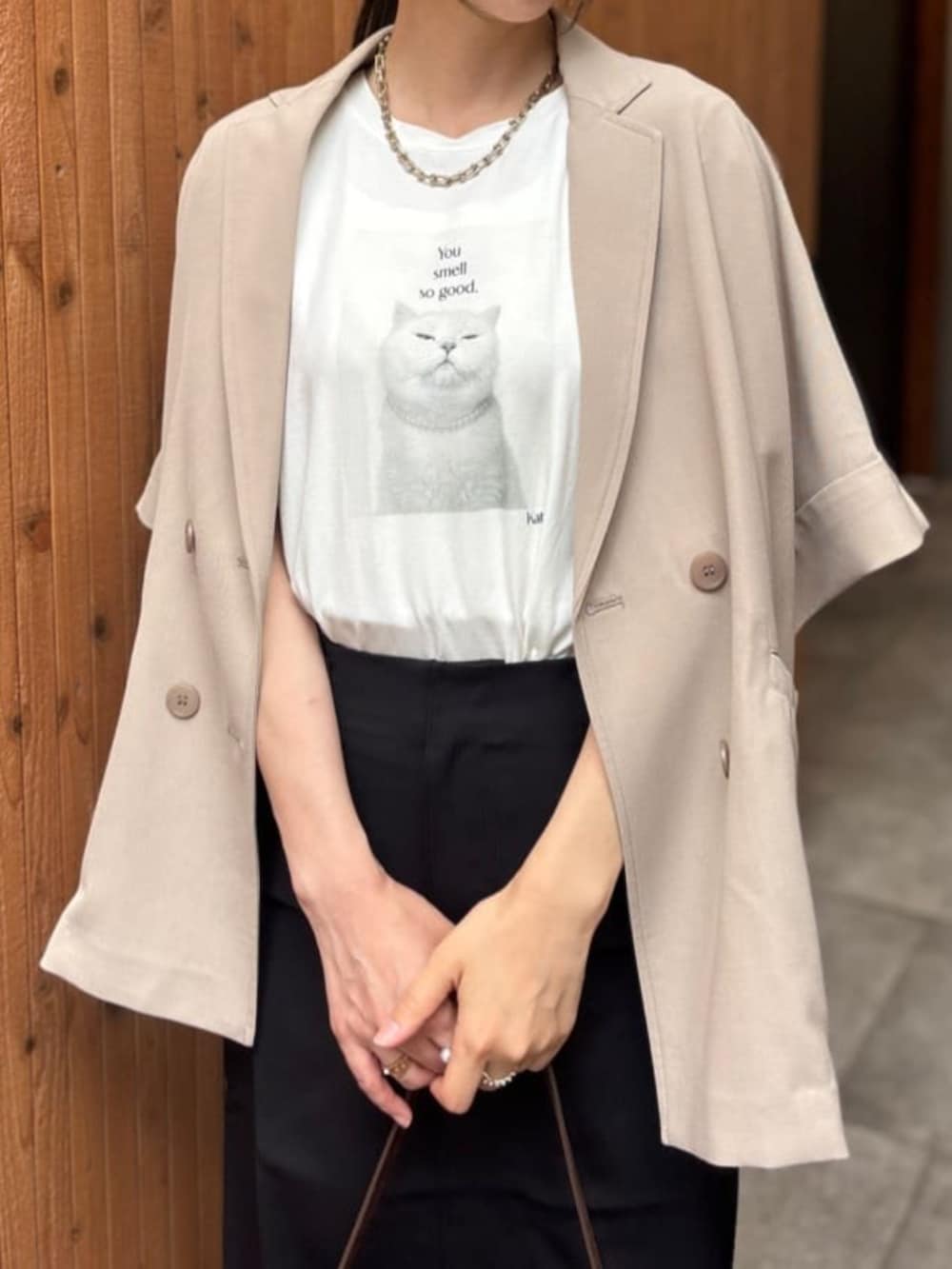 ベージュ系のテーラードジャケット、ブラウン系のショルダーバッグ、ホワイト系のTシャツ/カットソーを着用したレディースの夏コーディネートの4枚目の写真