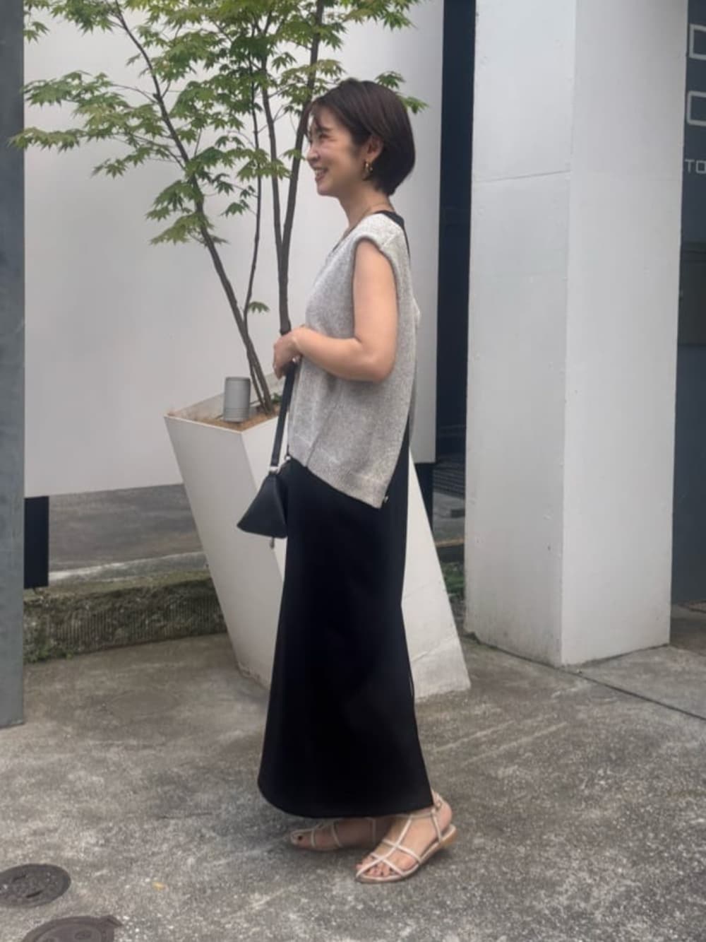 ブラック系のワンピースを着用したレディースの夏コーディネートの2枚目の写真