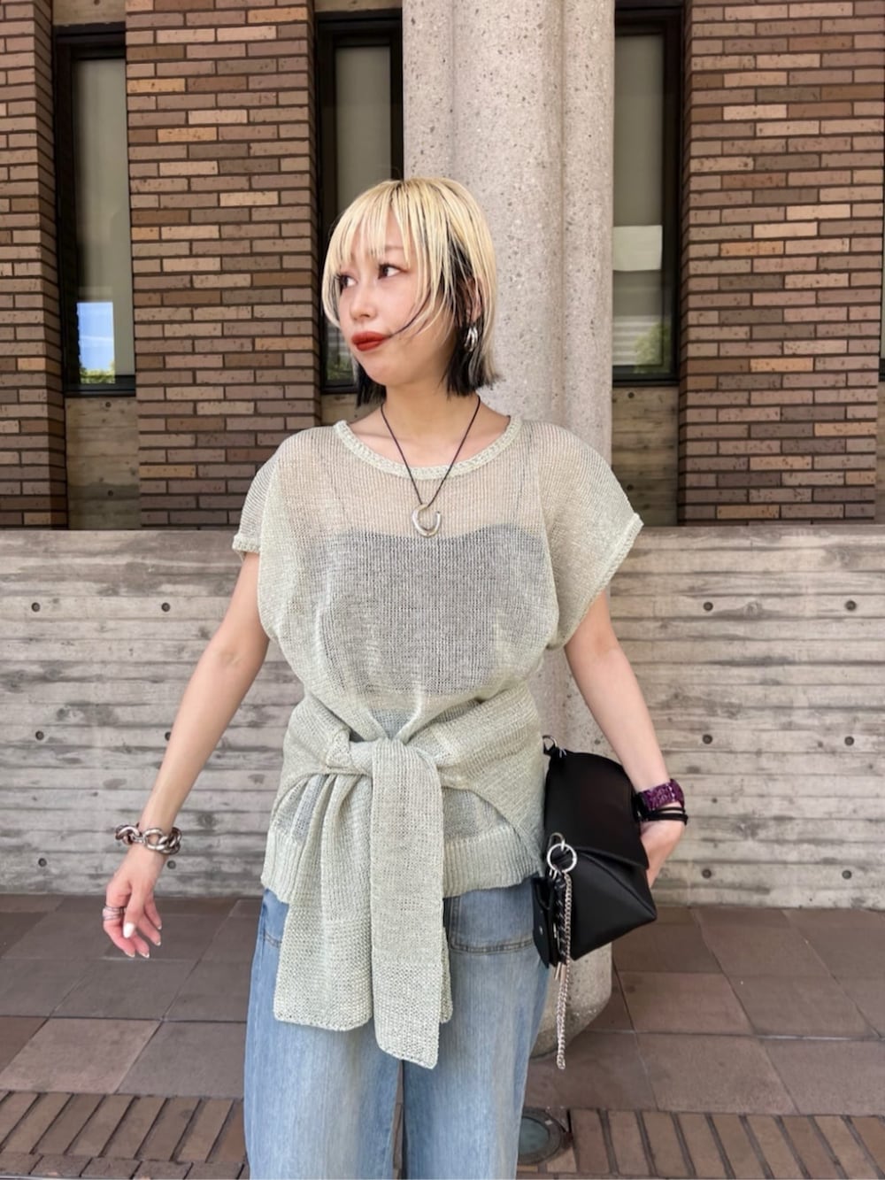 ブラック系のショルダーバッグ、グリーン系のニット/セーターを着用したレディースの夏コーディネートの4枚目の写真