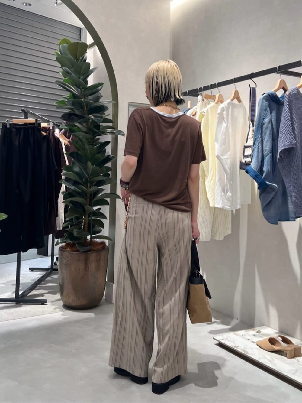 その他のスラックス、ブラウン系のTシャツ/カットソー、ブラック系のサンダルを着用したレディースの夏コーディネートの3枚目の写真