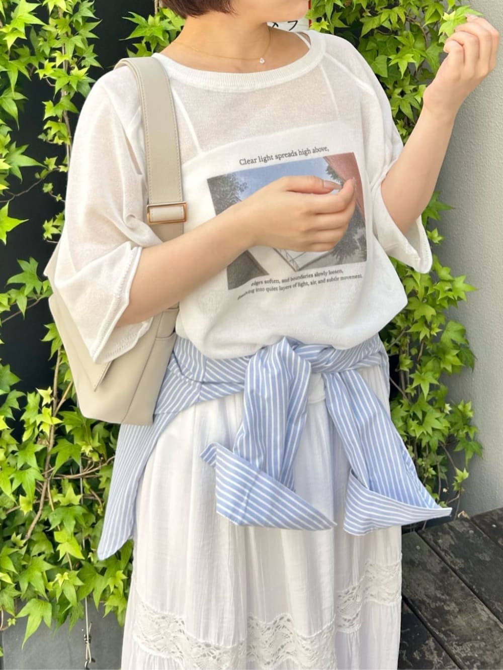 ホワイト系のショルダーバッグ、ホワイト系のスカート、ホワイト系のTシャツ/カットソーを着用したレディースの春コーディネートの3枚目の写真