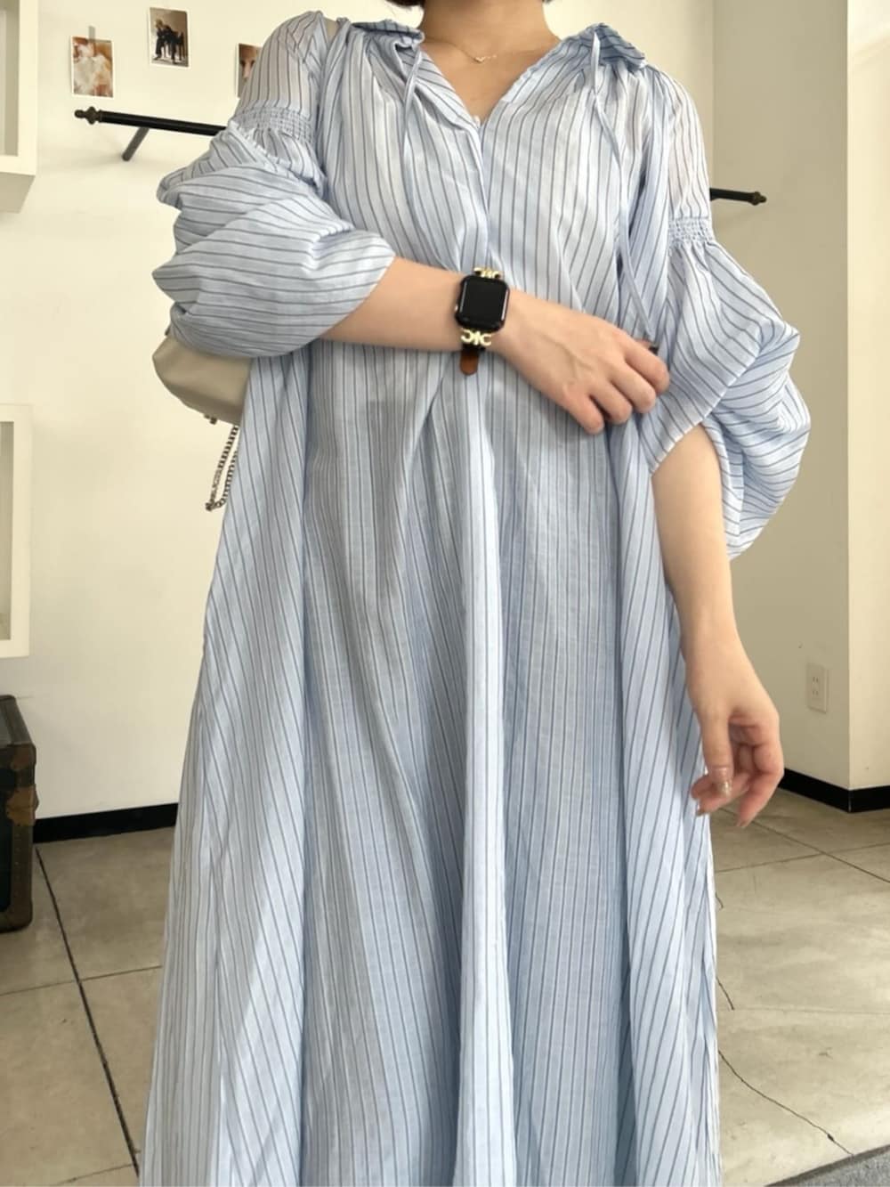 ホワイト系のショルダーバッグ、ブルー系のデニムパンツ、ブルー系のワンピースを着用したレディースの夏コーディネートの3枚目の写真