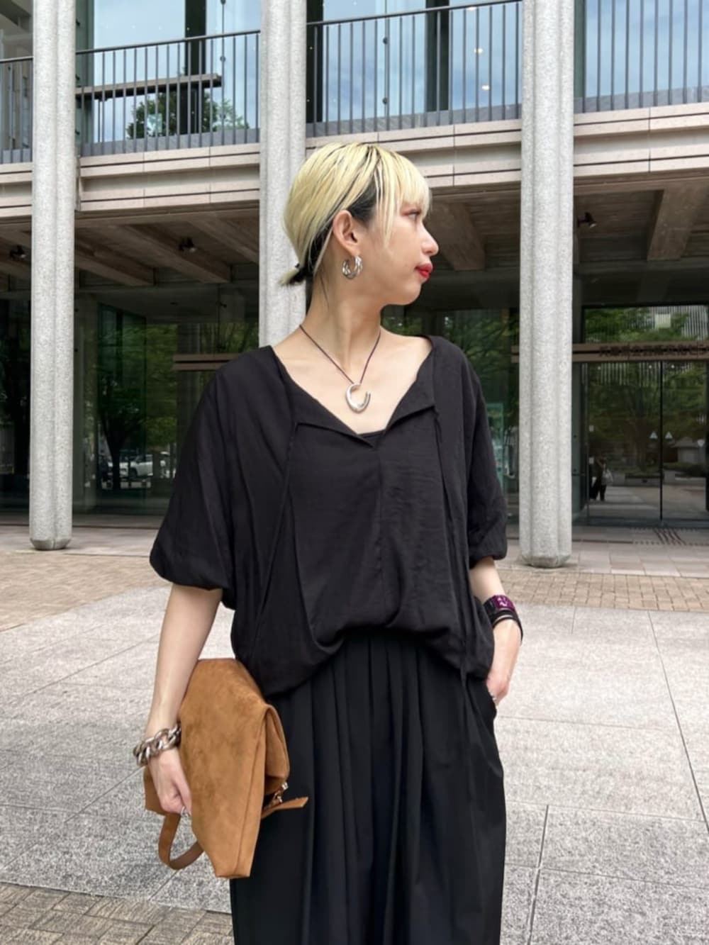 ブラック系のシャツ/ブラウスを着用したレディースの夏コーディネートの2枚目の写真