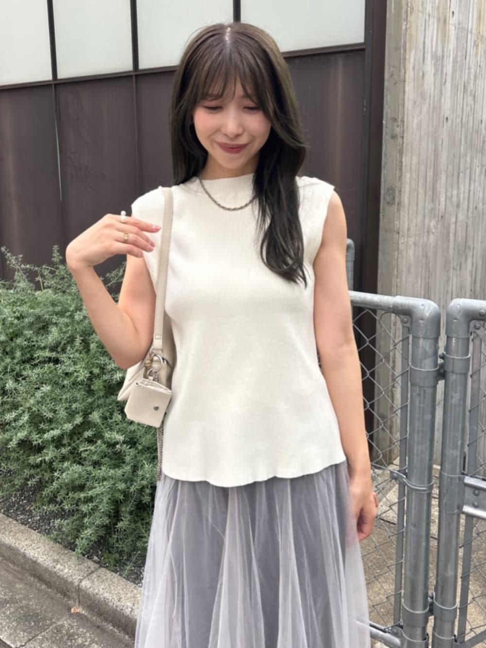 ホワイト系のショルダーバッグ、ホワイト系のニット/セーターを着用したレディースの夏コーディネートの2枚目の写真