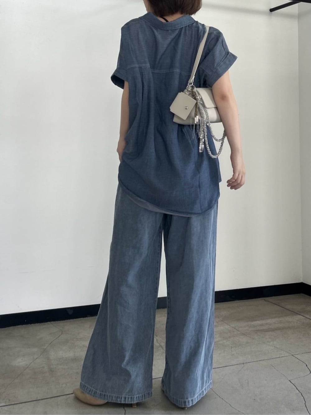 ホワイト系のショルダーバッグ、ブルー系のシャツ/ブラウス、ブルー系のデニムパンツを着用したレディースの夏コーディネートの4枚目の写真