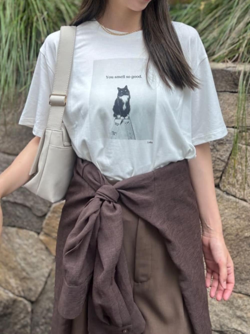 ブラウン系のシャツ/ブラウス、ホワイト系のショルダーバッグ、ブラウン系のスラックスを着用したレディースの夏コーディネートの2枚目の写真