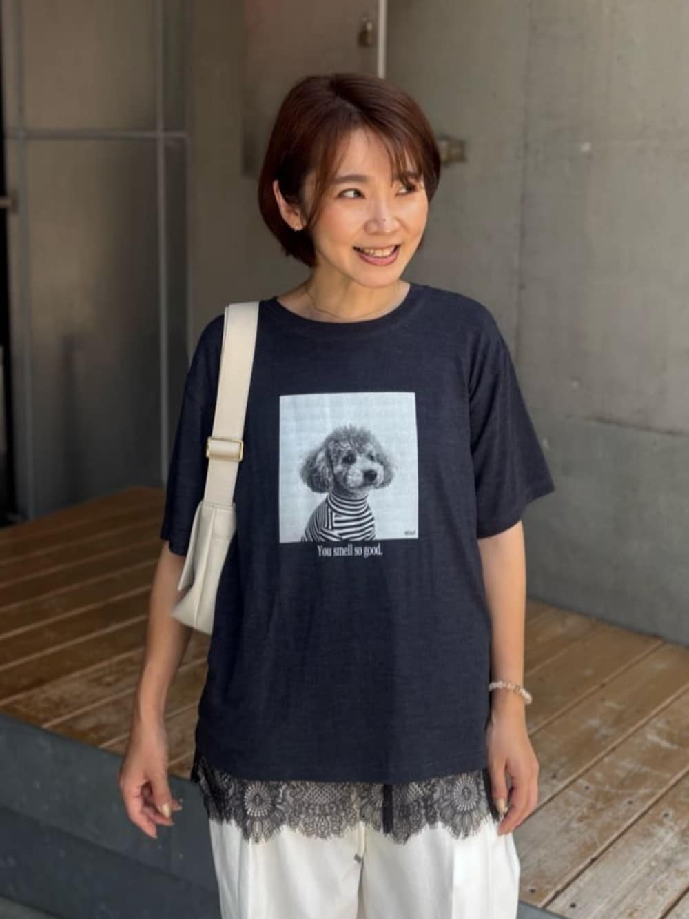 ホワイト系のショルダーバッグ、ブラック系のキャミソール、ホワイト系のデニムパンツを着用したレディースの夏コーディネートの4枚目の写真