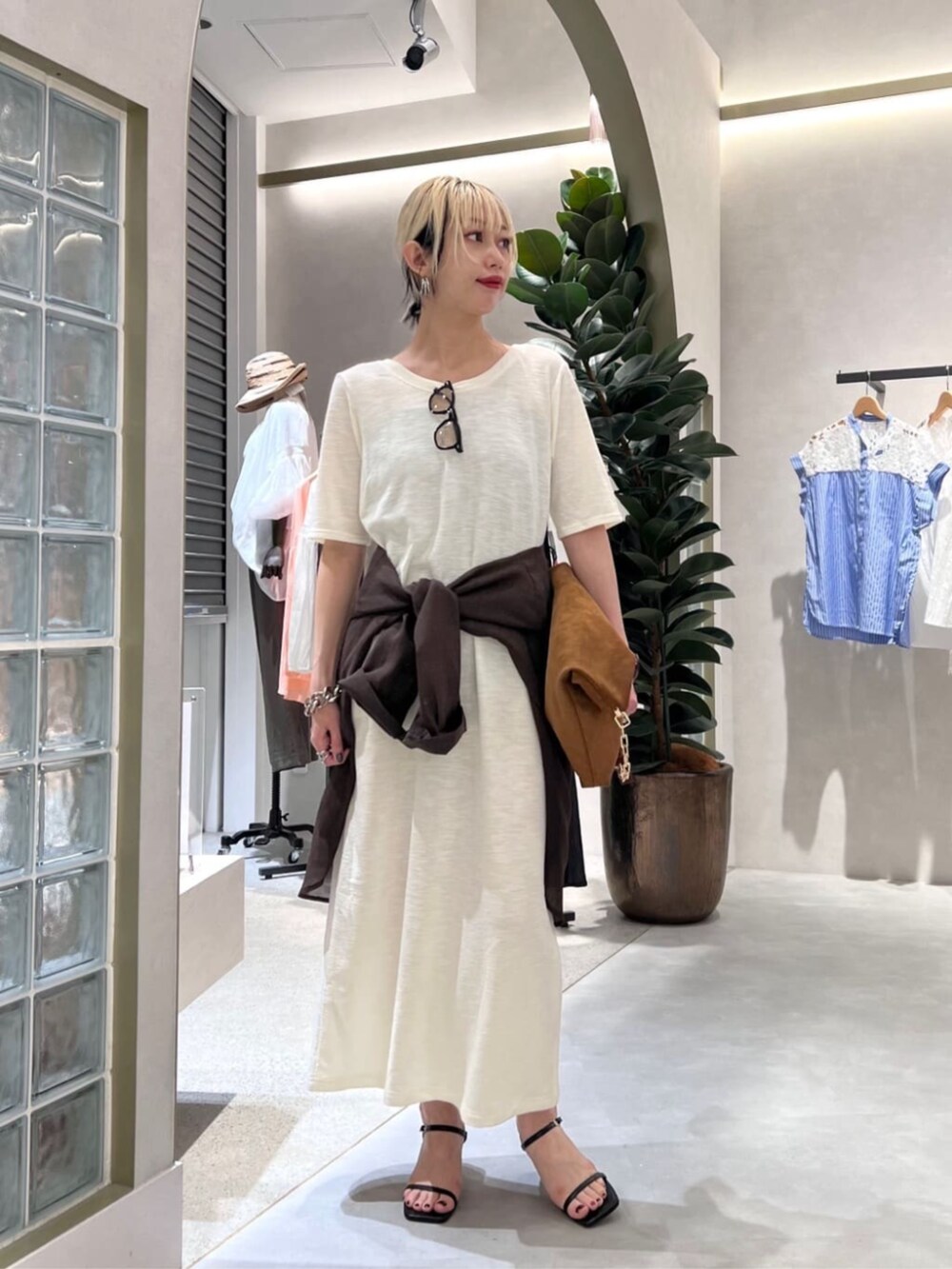 イエロー系のショルダーバッグ、ホワイト系のワンピース、ブラウン系のシャツ/ブラウスを着用したレディースの夏コーディネートの4枚目の写真