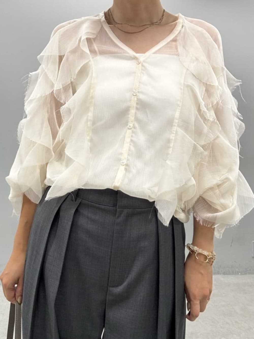 ベージュ系のショルダーバッグ、ホワイト系のシャツ/ブラウスを着用したレディースの夏コーディネートの3枚目の写真