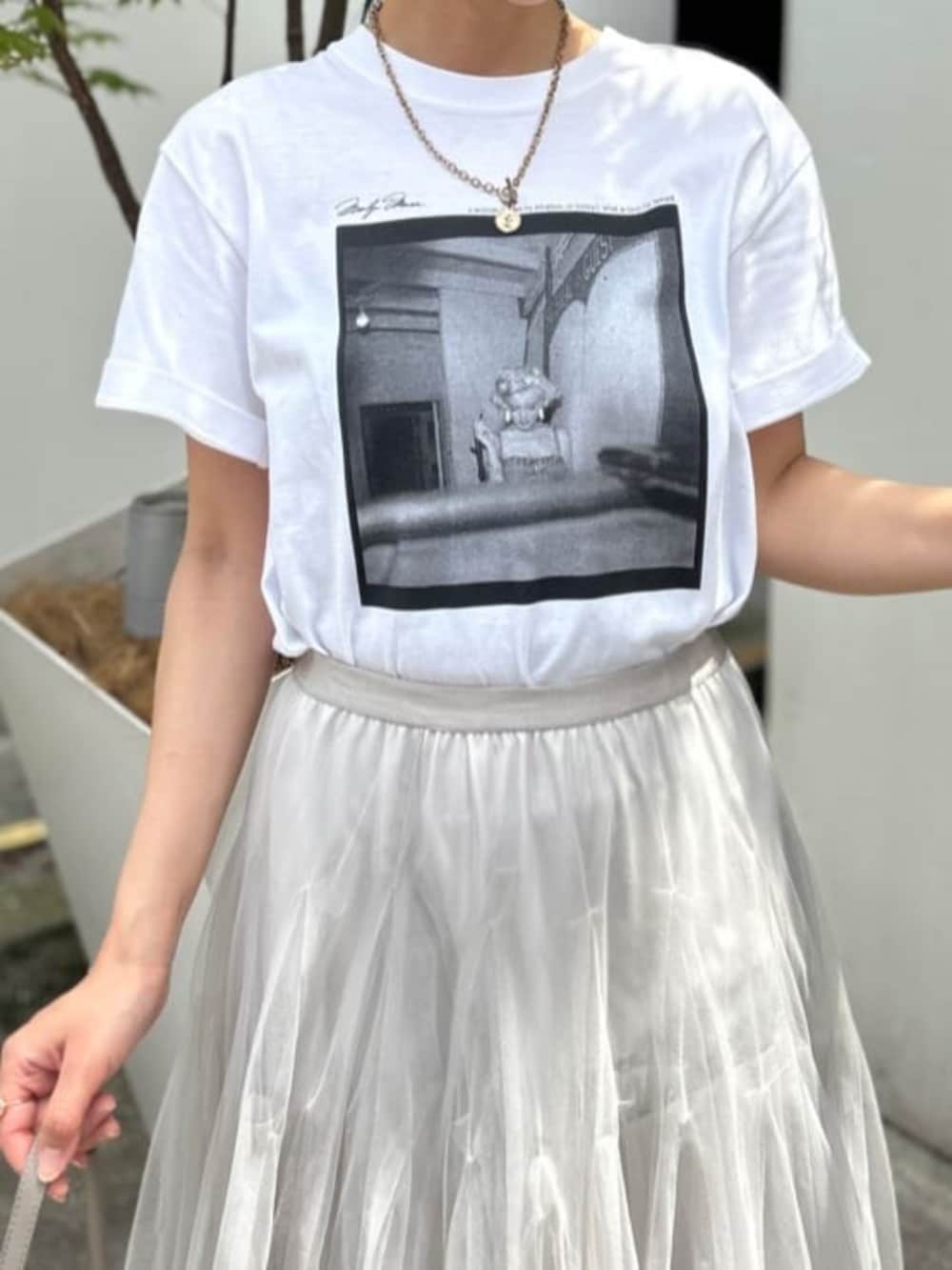 ベージュ系のショルダーバッグ、ホワイト系のTシャツ/カットソー、ベージュ系のスカートを着用したレディースの夏コーディネートの3枚目の写真