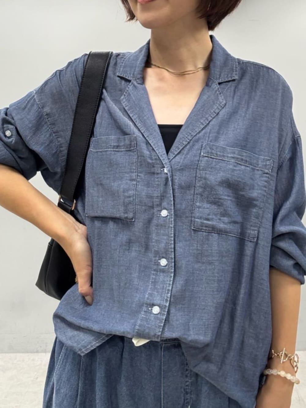 ブラック系のキャミソール、ブルー系のシャツ/ブラウス、ブラック系のショルダーバッグを着用したレディースの夏コーディネートの2枚目の写真