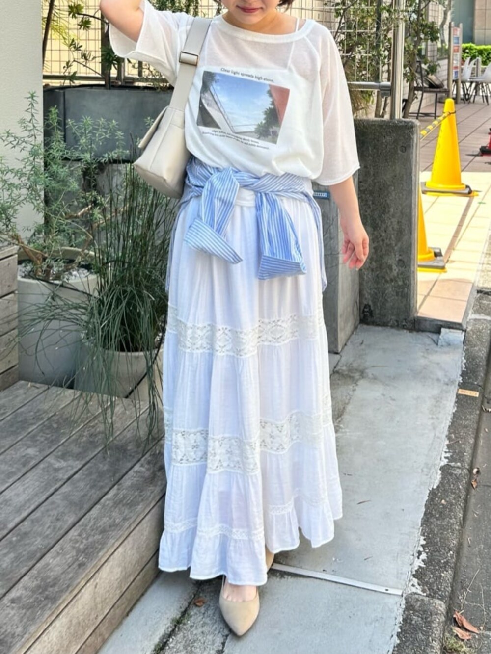 ホワイト系のショルダーバッグ、ホワイト系のスカート、ホワイト系のTシャツ/カットソーを着用したレディースの春コーディネートの2枚目の写真
