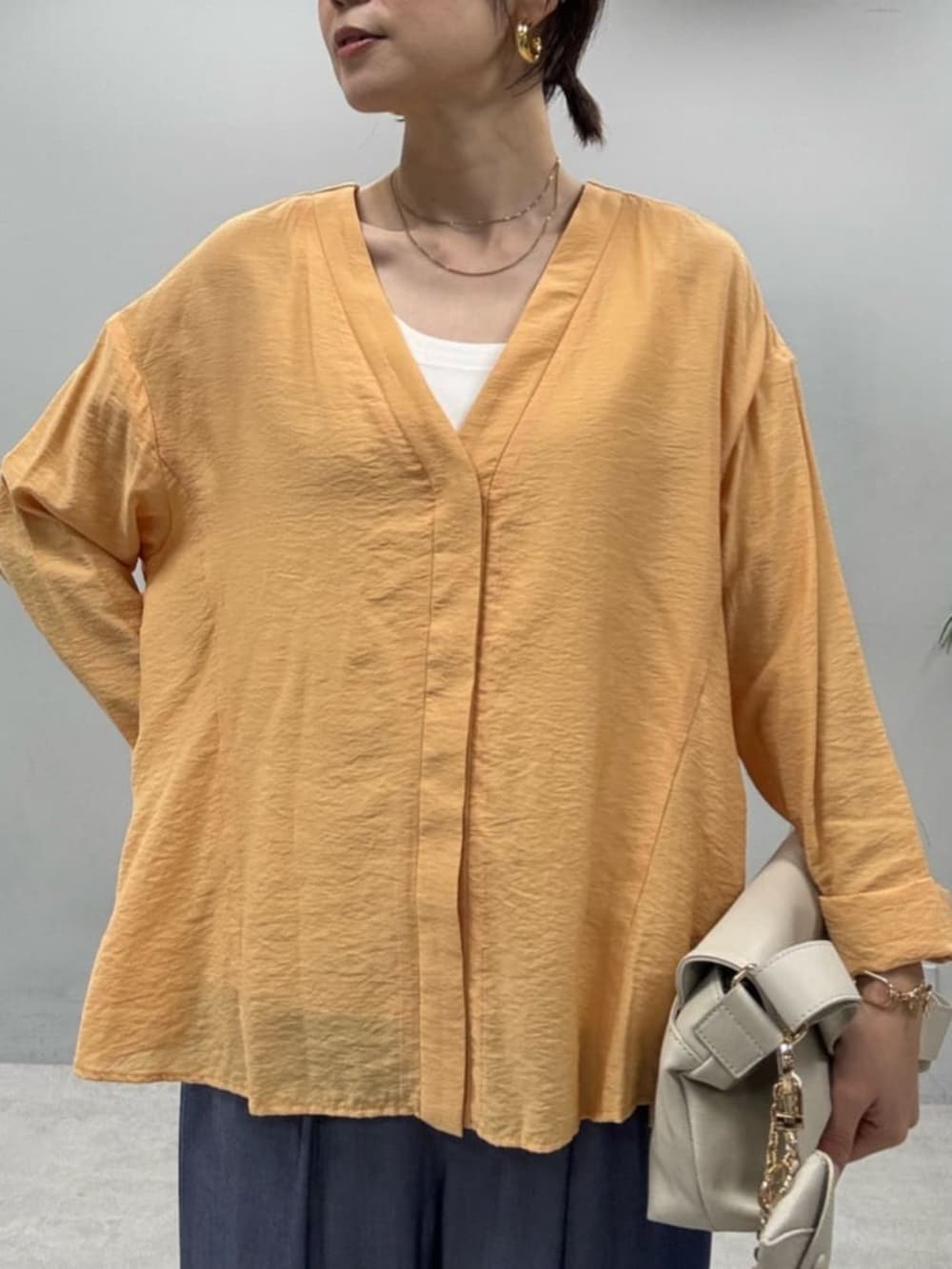 ブルー系のその他パンツ、オレンジ系のシャツ/ブラウスを着用したレディースの春コーディネートの2枚目の写真