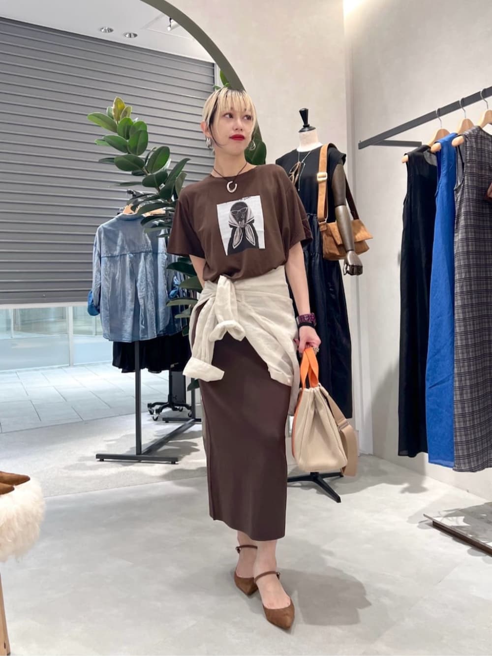 ブラウン系のTシャツ/カットソー、ブラウン系のスカートを着用したレディースの夏コーディネートの2枚目の写真