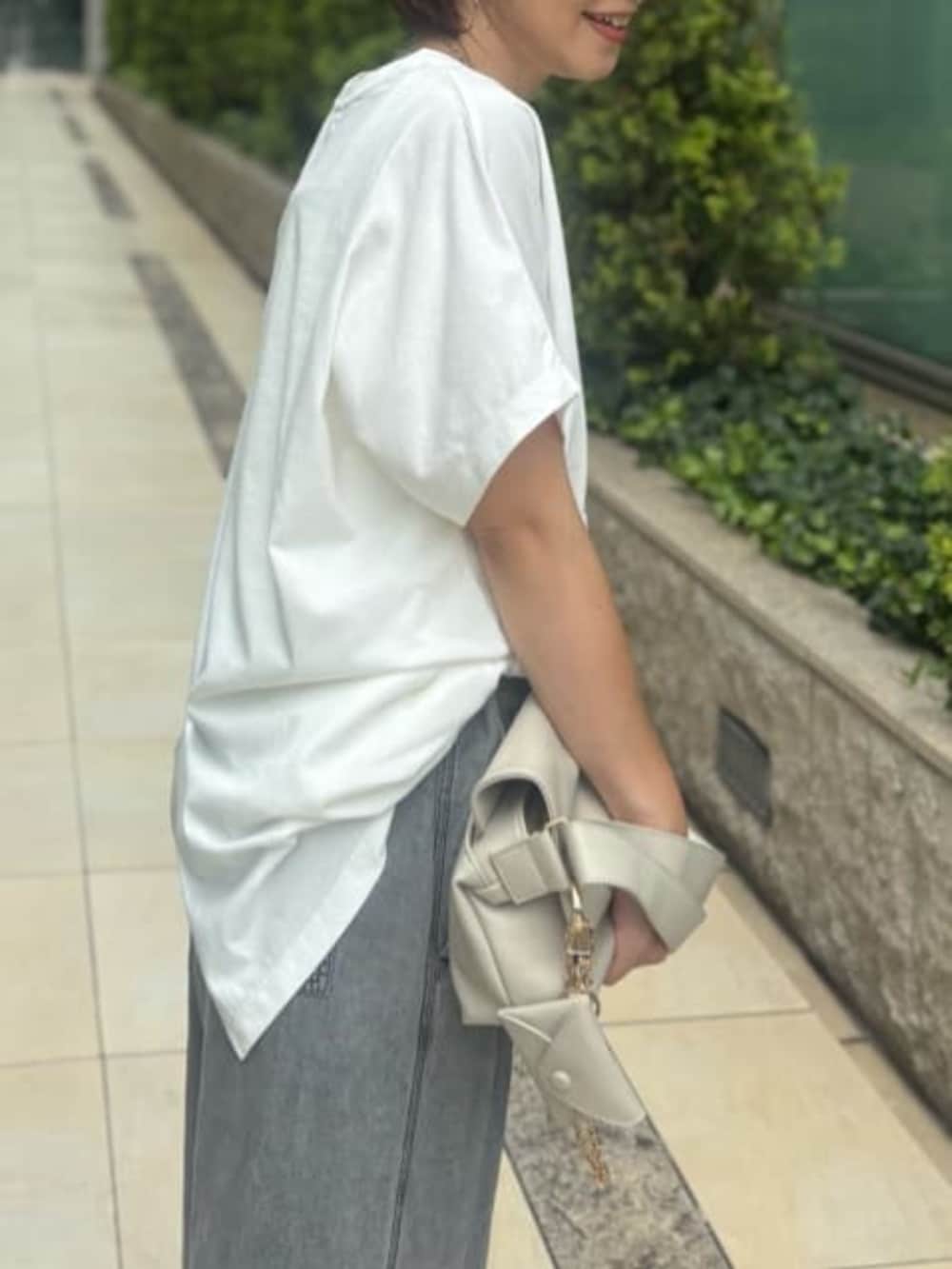 ホワイト系のショルダーバッグ、ホワイト系のTシャツ/カットソー、ブラック系のデニムパンツを着用したレディースの夏コーディネートの4枚目の写真