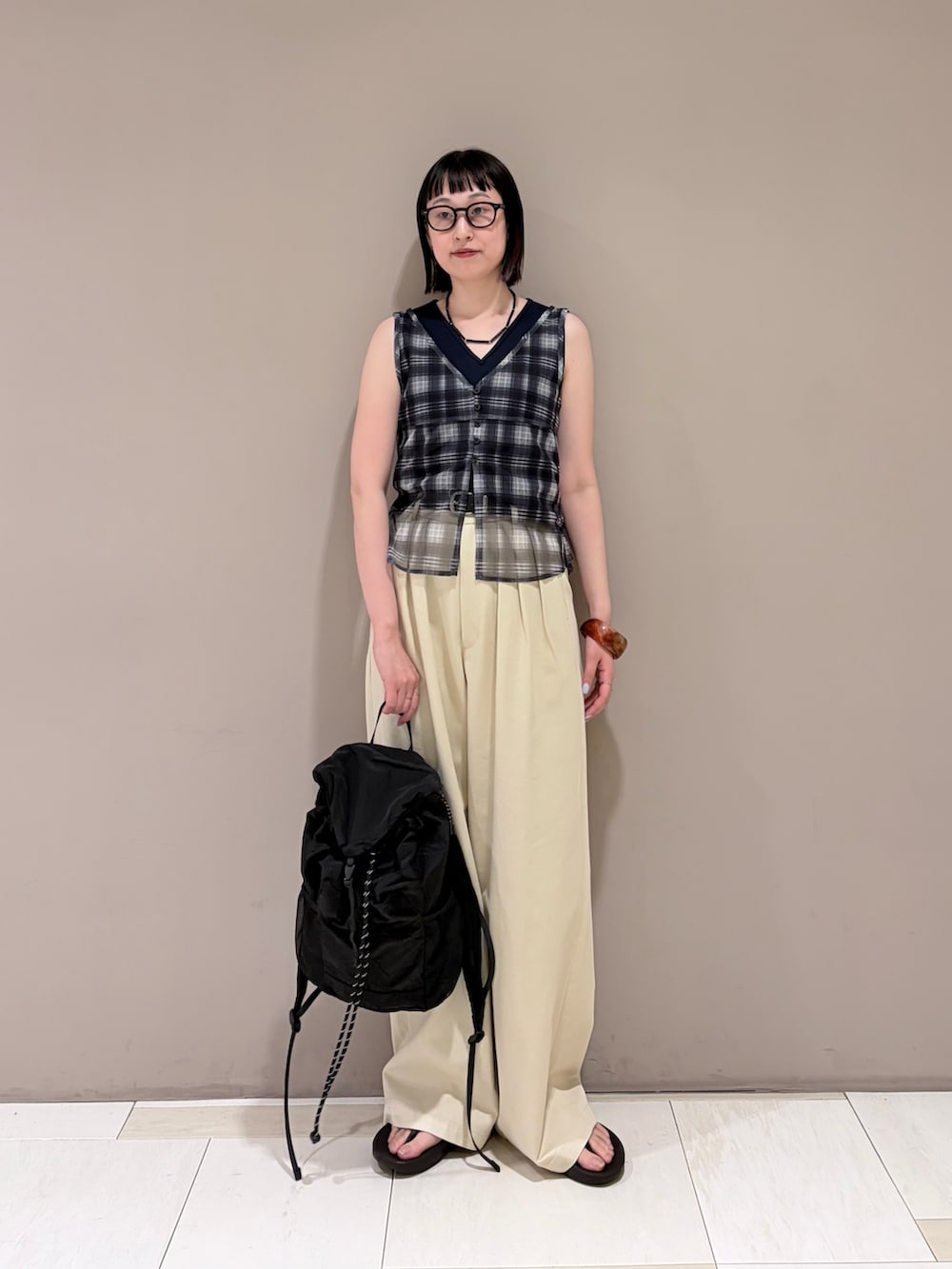 ベージュ系のその他パンツ、ブルー系のタンクトップ、ブラック系のバックパック/リュックを着用したレディースの夏コーディネートの3枚目の写真