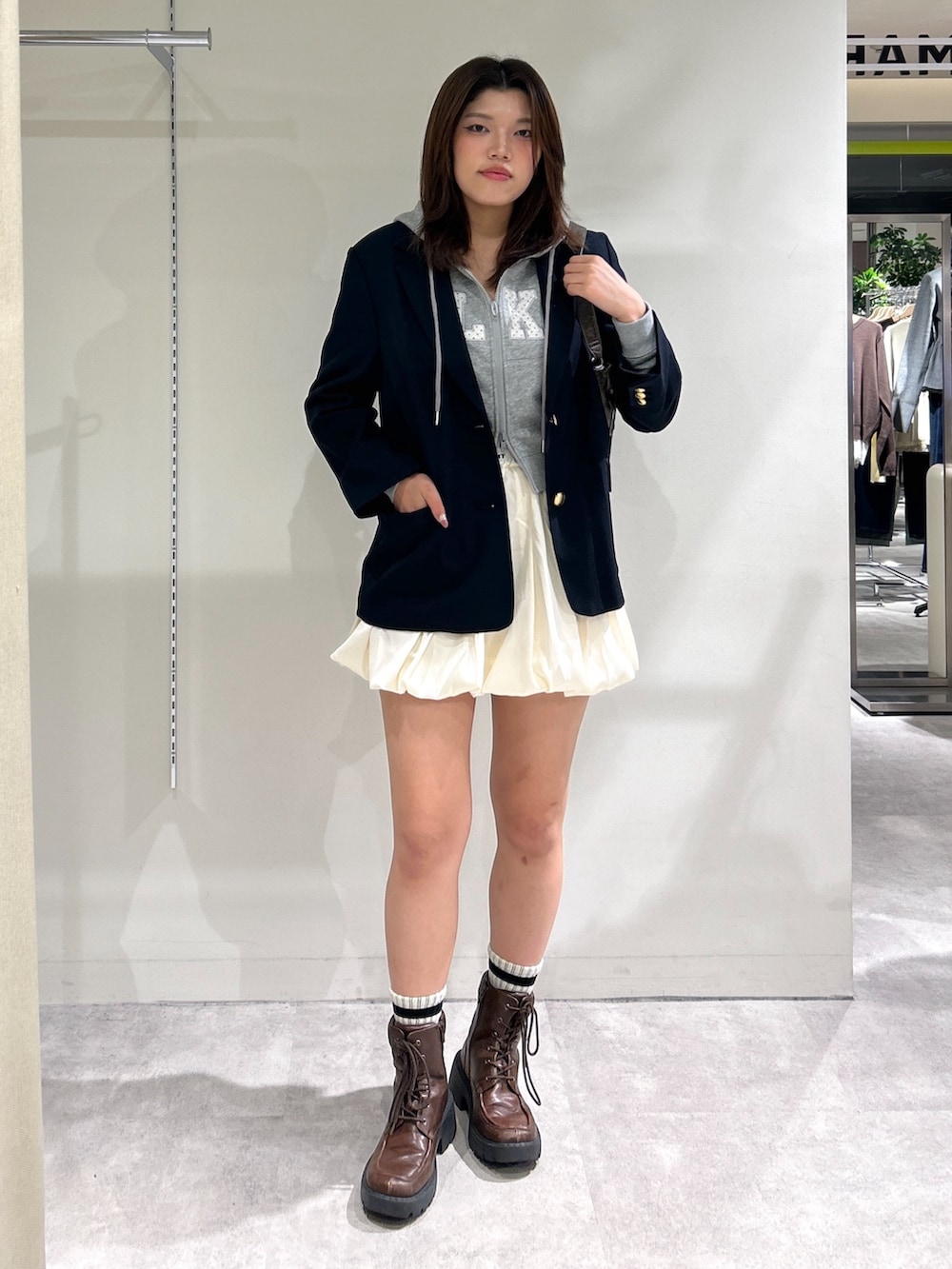 ホワイト系のスカート、ブルー系のテーラードジャケット、グレー系のTシャツ/カットソーを着用したレディースの秋コーディネートの2枚目の写真