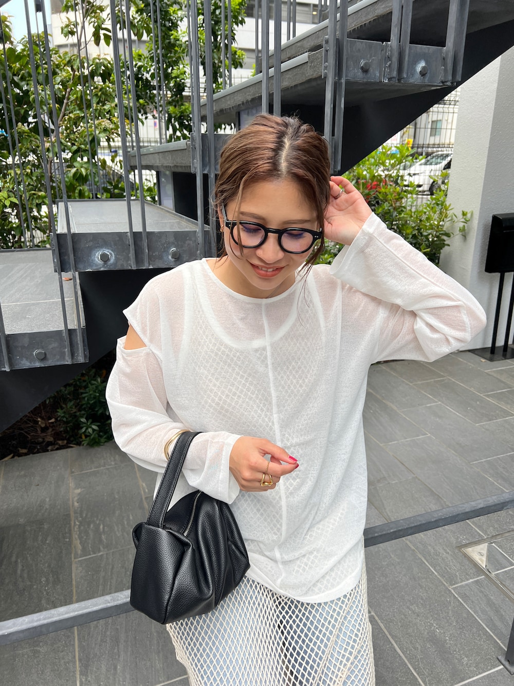 ブラック系のショルダーバッグ、ホワイト系のワンピース、ホワイト系のTシャツ/カットソーを着用したレディースの春コーディネートの3枚目の写真