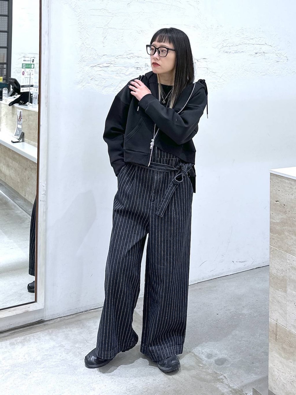 ブラック系のサロペット/オーバーオール、ブラック系のボストンバッグ、ブラック系のパーカーを着用したレディースの冬コーディネートの4枚目の写真