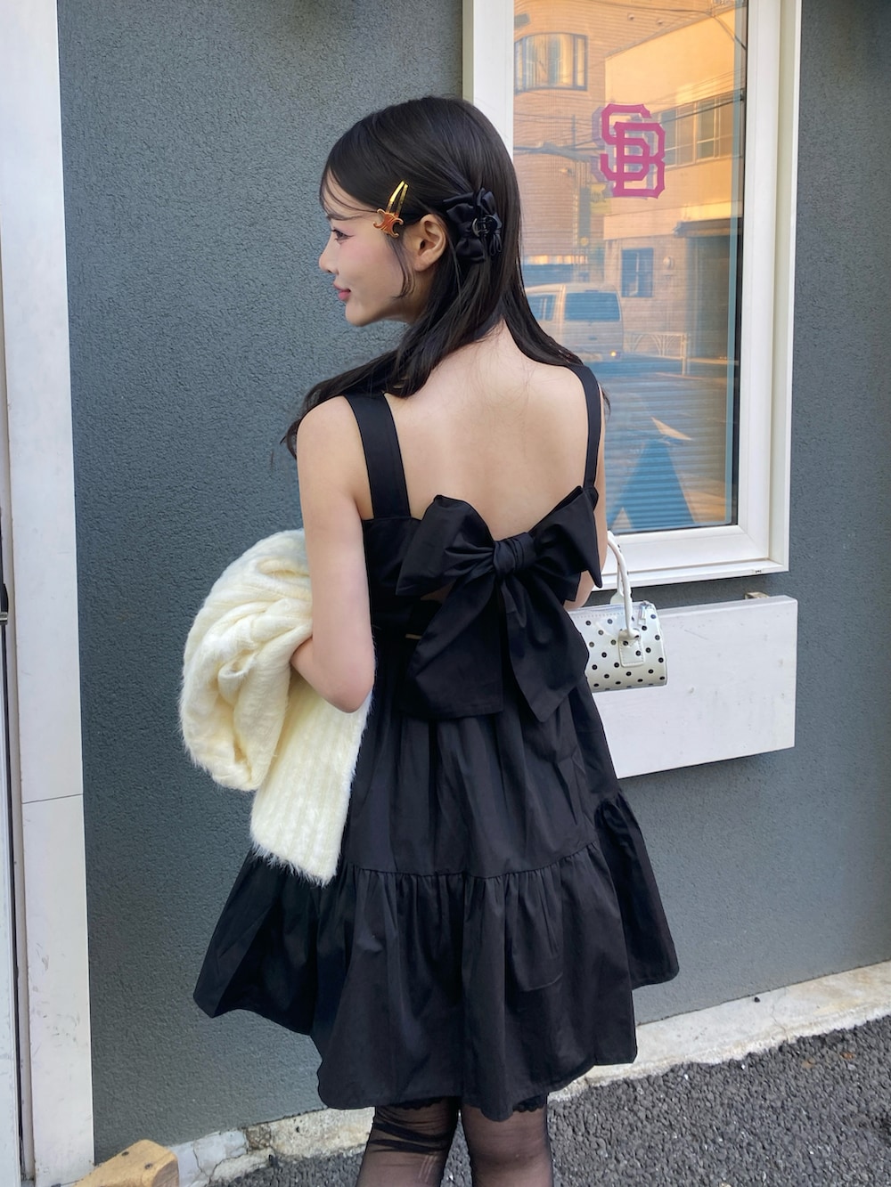 ブラック系のワンピース、ブラック系のパンプスを着用したレディースの冬コーディネートの2枚目の写真