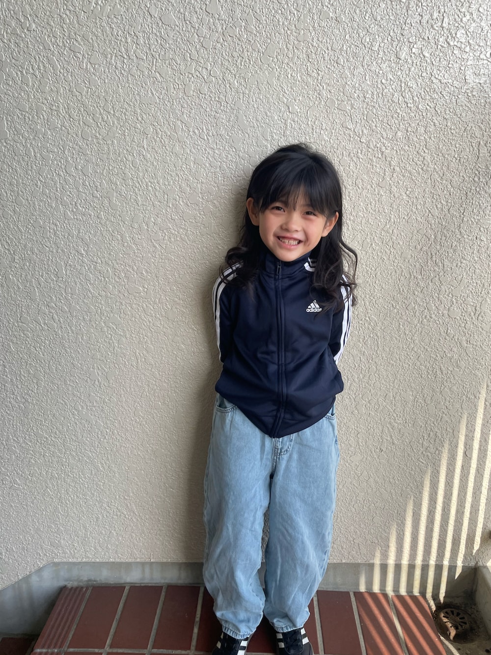 ブルー系のジャージ、ブルー系のデニムパンツ、ブラック系のスニーカーを着用したキッズの春コーディネートの2枚目の写真