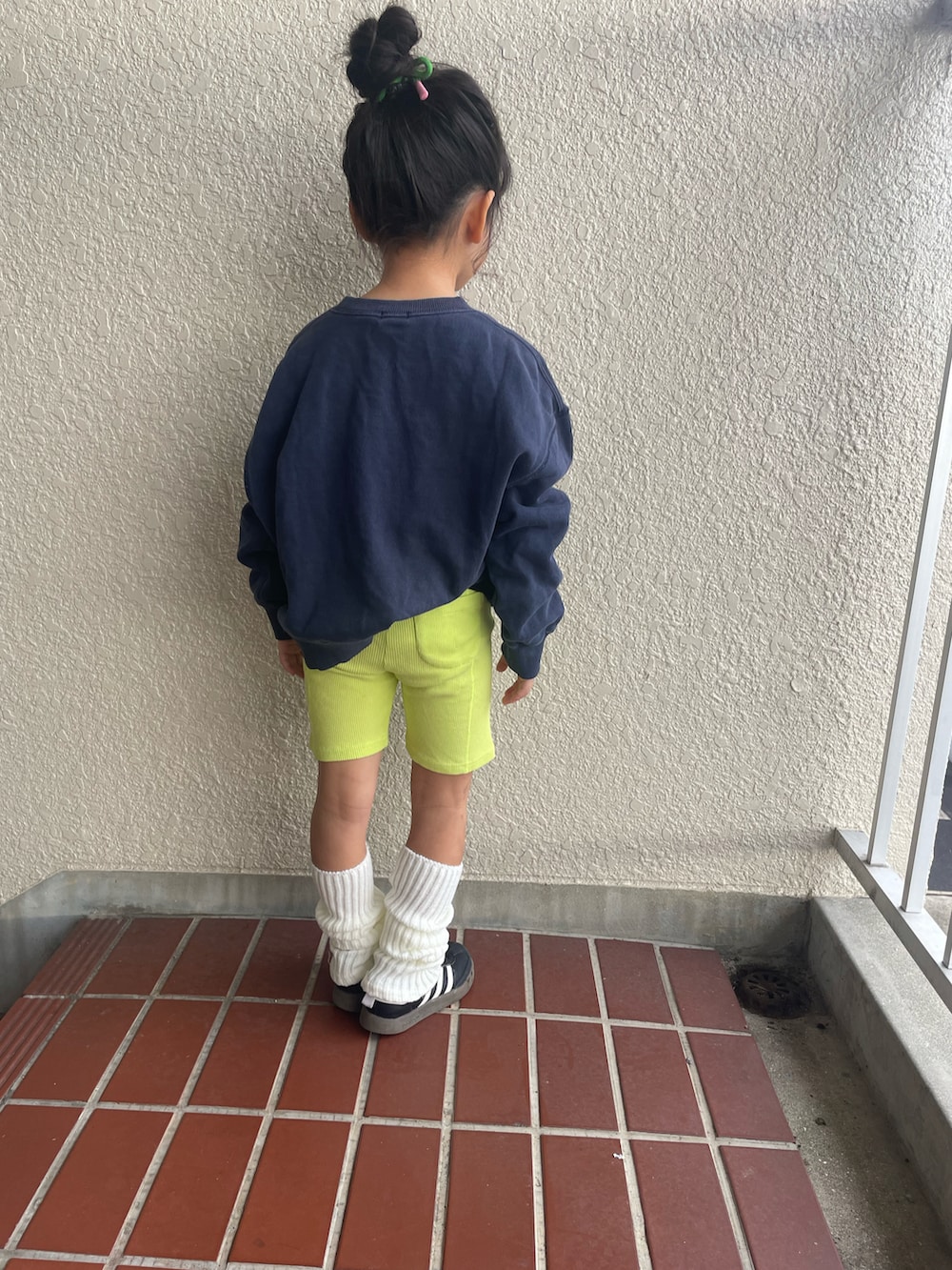 ブルー系のスウェット、ブラック系のスニーカー、イエロー系のレギンス/スパッツを着用したキッズの冬コーディネートの2枚目の写真