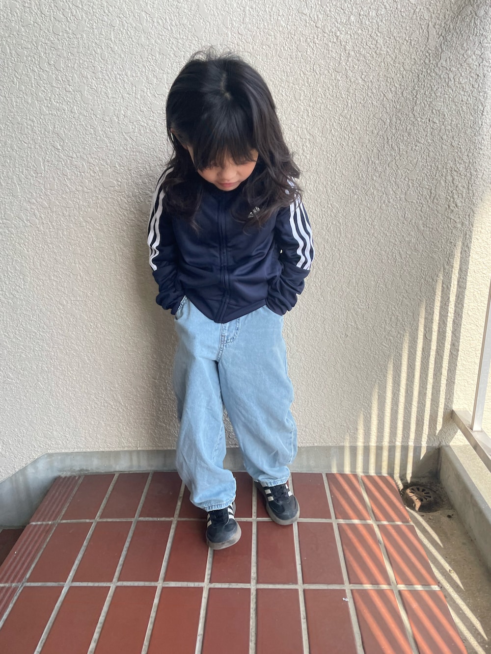 ブルー系のジャージ、ブルー系のデニムパンツ、ブラック系のスニーカーを着用したキッズの春コーディネートの4枚目の写真