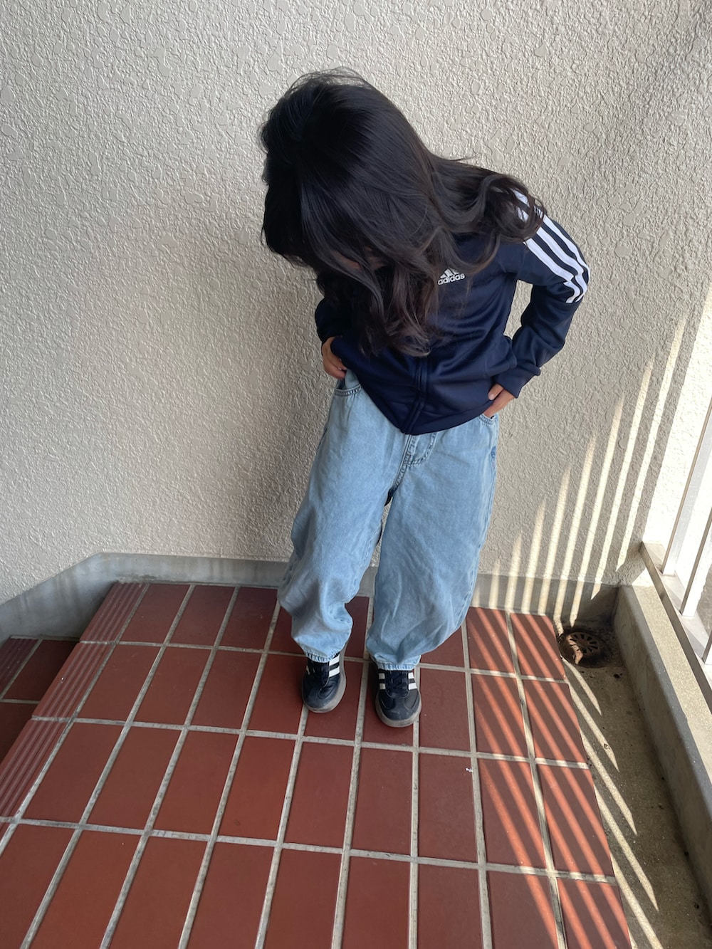 ブルー系のジャージ、ブルー系のデニムパンツ、ブラック系のスニーカーを着用したキッズの春コーディネートの3枚目の写真