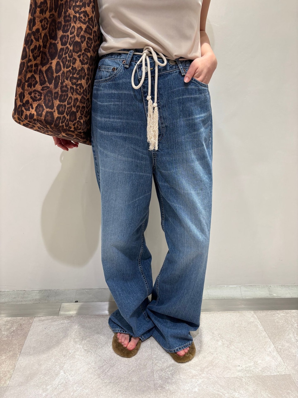 ブルー系のデニムパンツ、イエロー系のトートバッグ、イエロー系のサンダルを着用したレディースの夏コーディネートの8枚目の写真