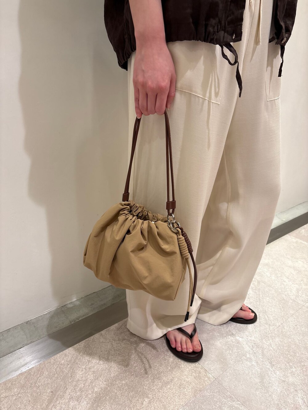 ホワイト系のその他パンツ、ブラウン系のタンクトップ、ベージュ系のハンドバッグを着用したレディースの春コーディネートの7枚目の写真