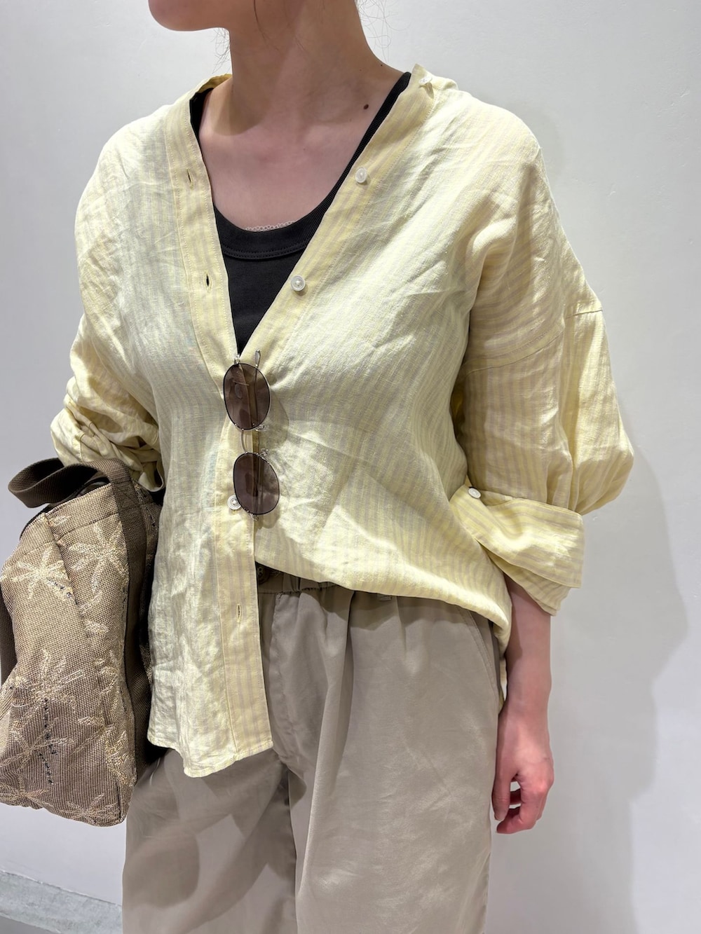 ベージュ系のその他パンツ、イエロー系のシャツ/ブラウス、ブラック系のタンクトップを着用したレディースの夏コーディネートの5枚目の写真