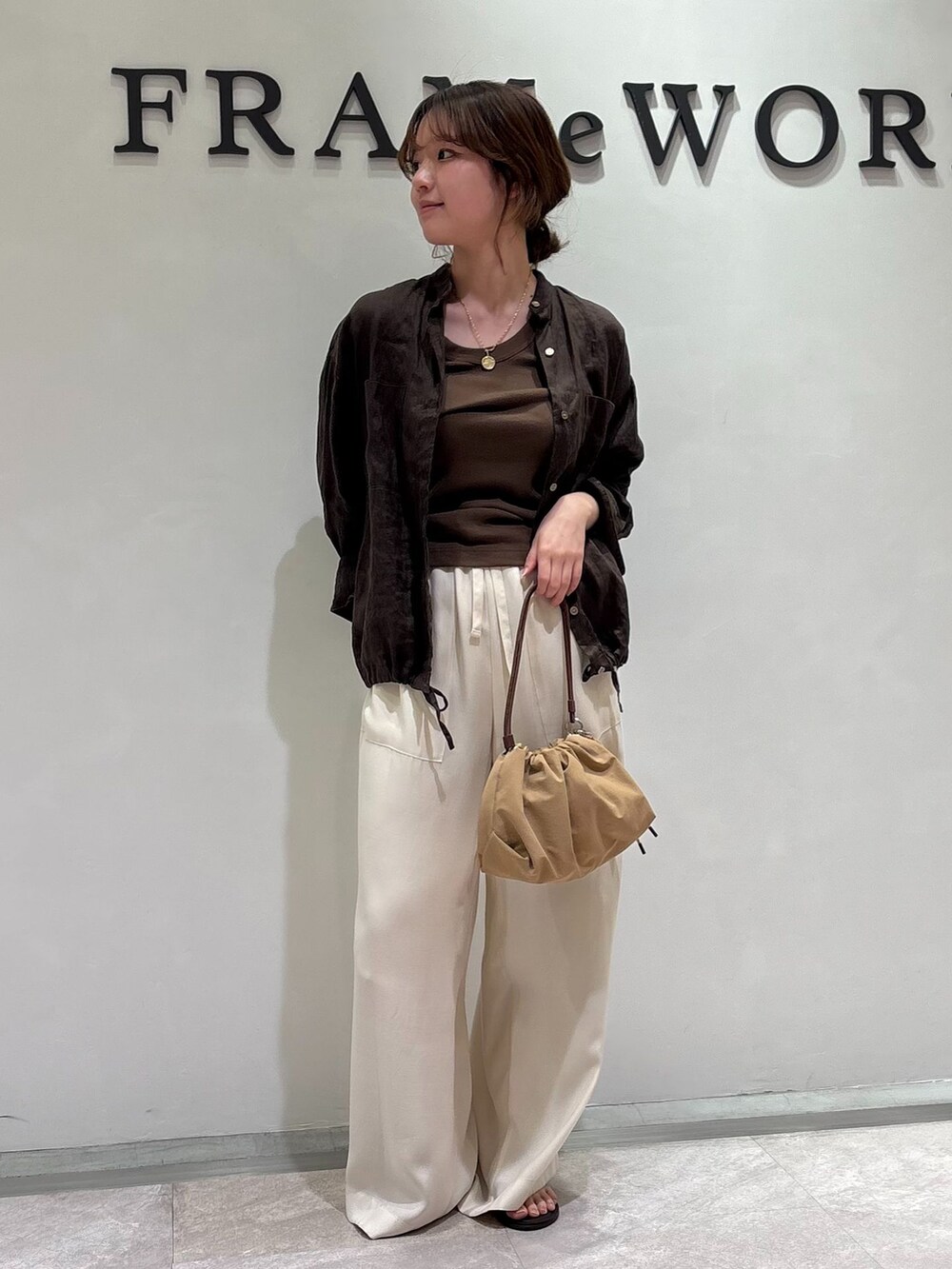 ホワイト系のその他パンツ、ブラウン系のタンクトップ、ベージュ系のハンドバッグを着用したレディースの春コーディネートの4枚目の写真