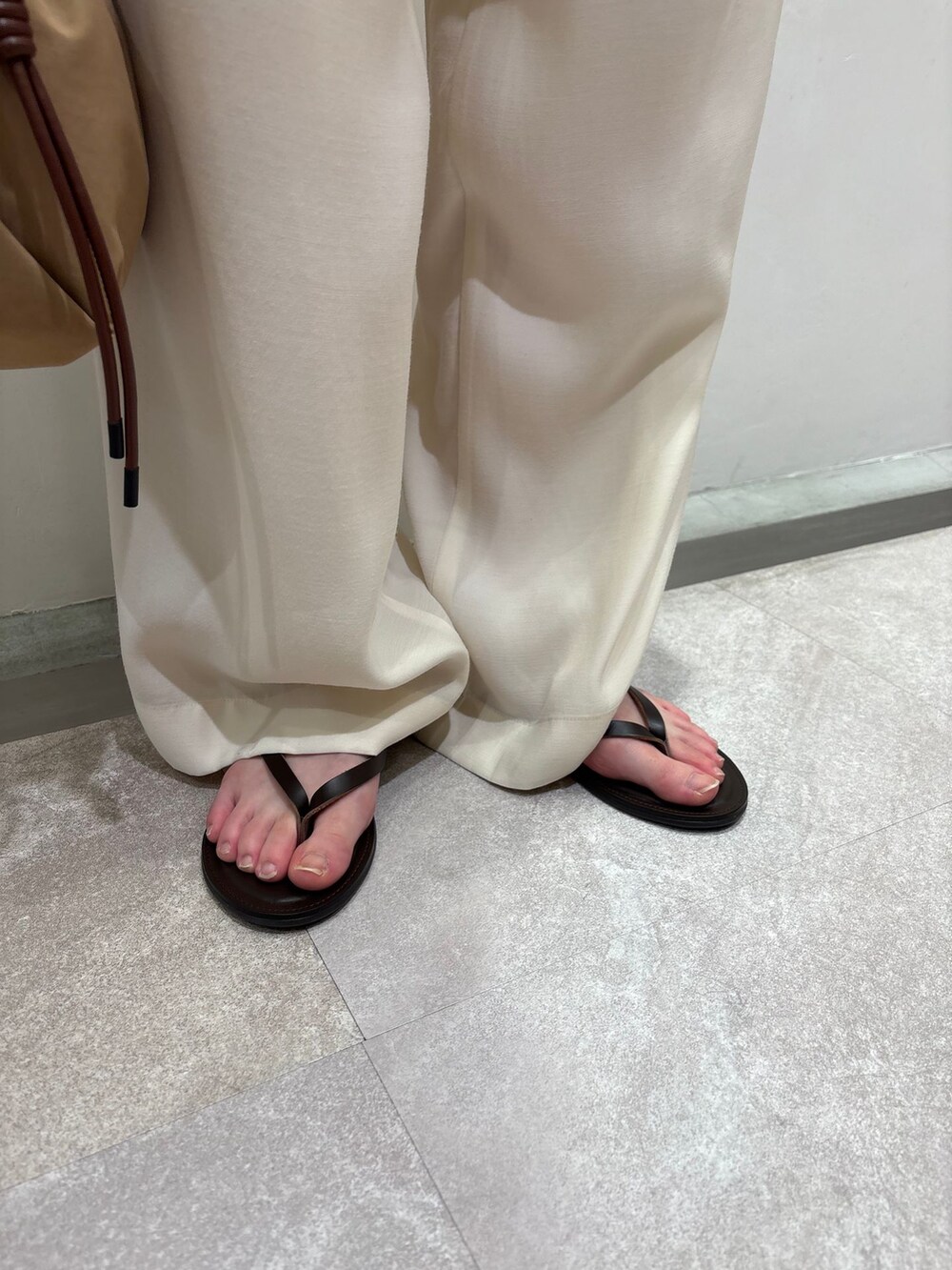 ホワイト系のその他パンツ、ブラウン系のタンクトップ、ベージュ系のハンドバッグを着用したレディースの春コーディネートの8枚目の写真