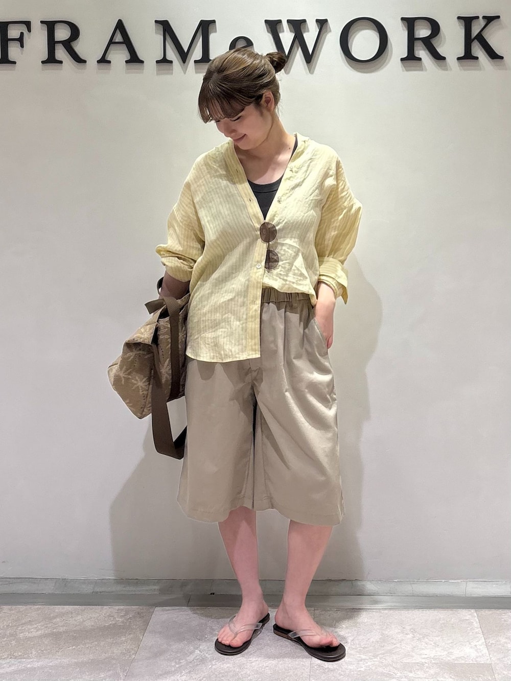 ベージュ系のその他パンツ、イエロー系のシャツ/ブラウス、ブラック系のタンクトップを着用したレディースの夏コーディネートの2枚目の写真