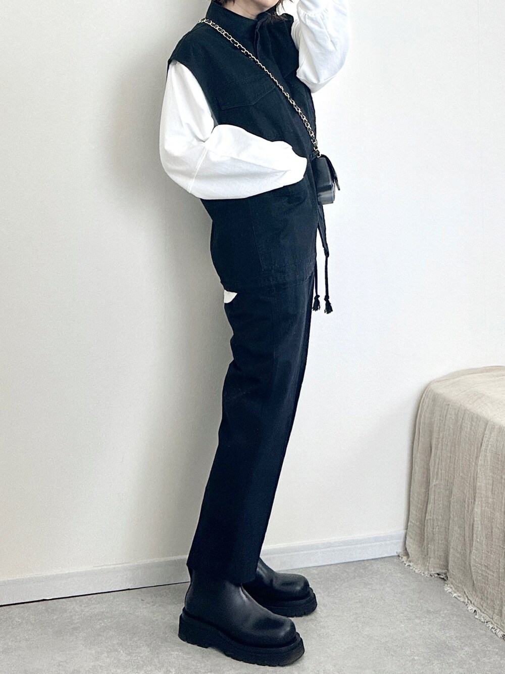 ブラック系のベスト、ブラック系のその他パンツ、ホワイト系のTシャツ/カットソーを着用したレディースの冬コーディネートの3枚目の写真