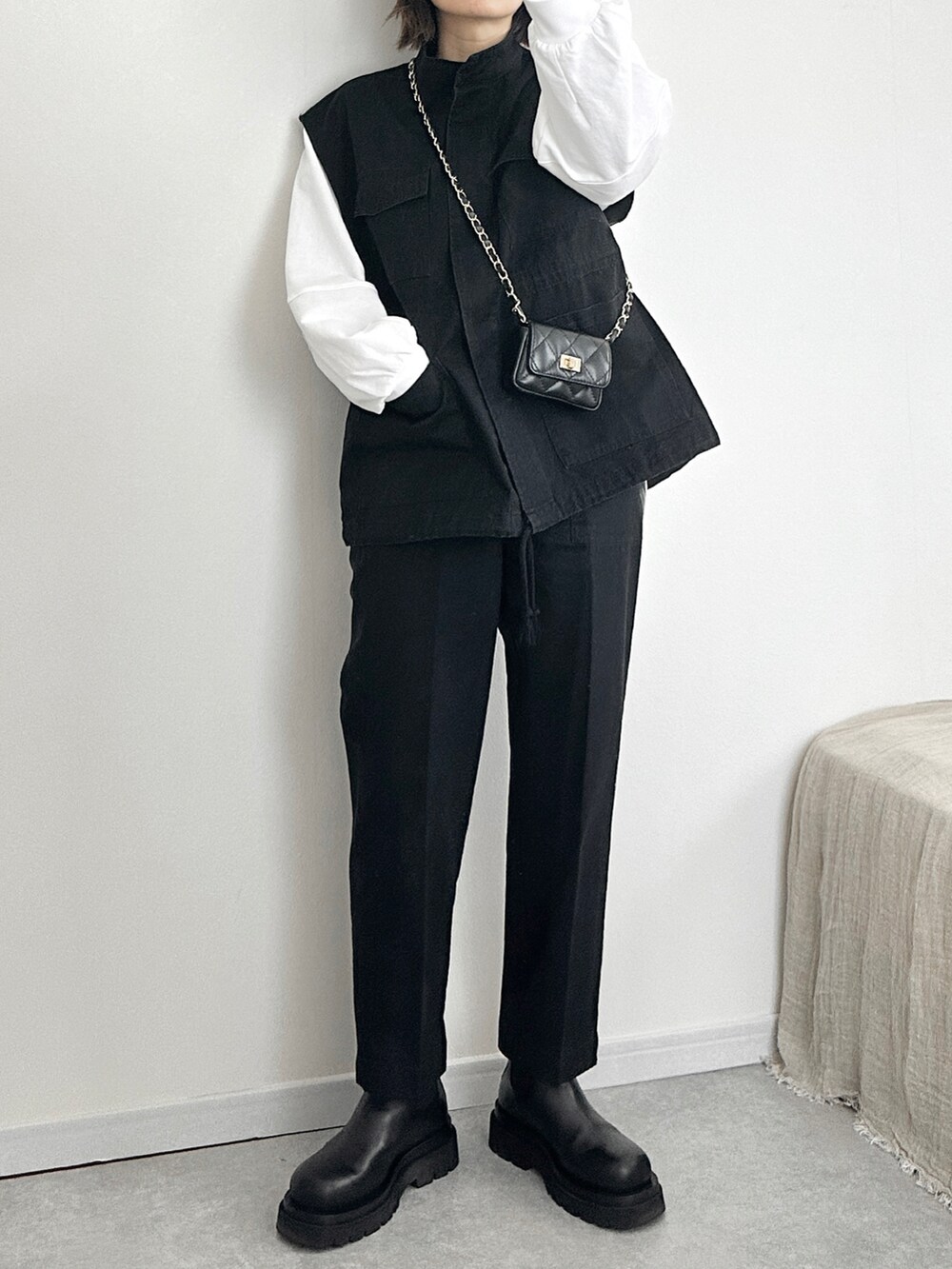 ブラック系のベスト、ブラック系のその他パンツ、ホワイト系のTシャツ/カットソーを着用したレディースの冬コーディネートの2枚目の写真