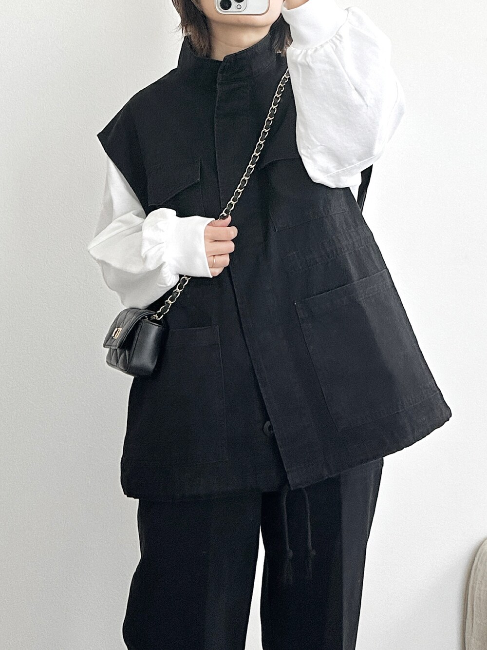 ブラック系のベスト、ブラック系のその他パンツ、ホワイト系のTシャツ/カットソーを着用したレディースの冬コーディネートの5枚目の写真