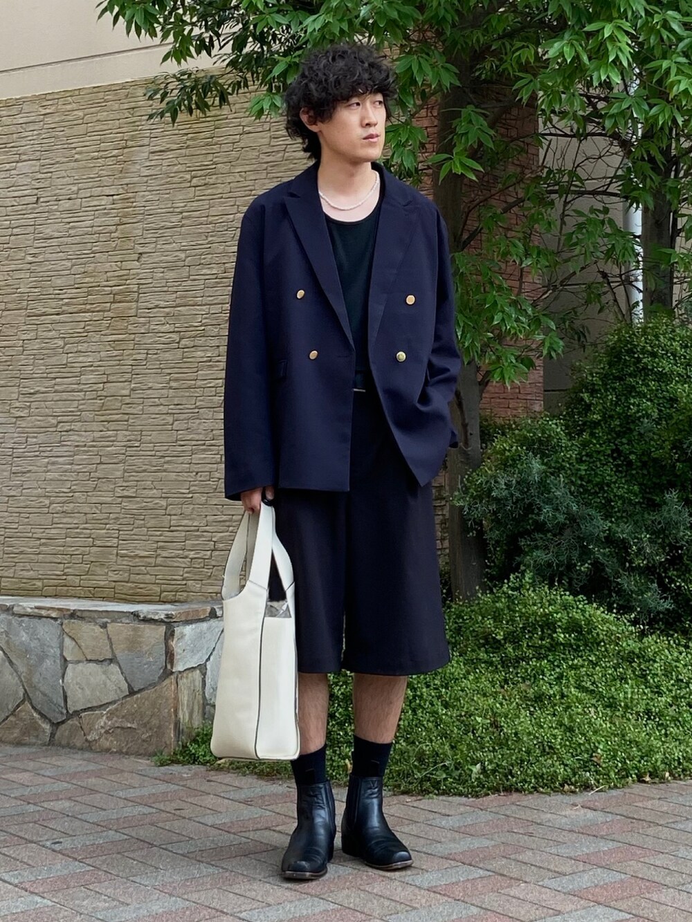 ホワイト系のショルダーバッグ、ブラック系のタンクトップ、ブルー系のテーラードジャケットを着用したメンズの夏コーディネートの2枚目の写真