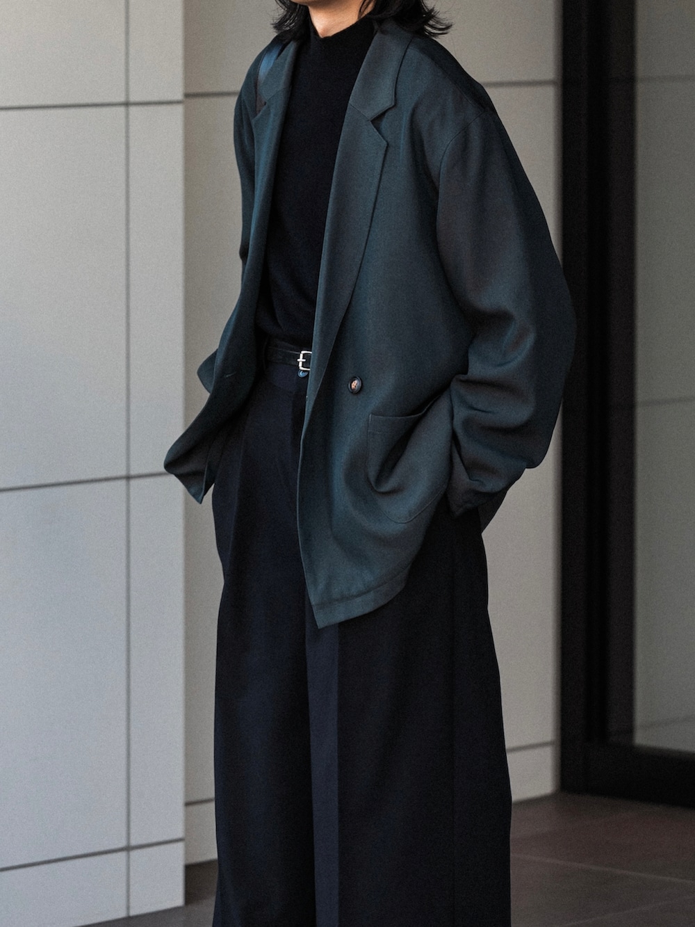 ブラック系のニット/セーター、ブラック系のスラックス、グレー系のその他アウターを着用したメンズの秋コーディネートの4枚目の写真