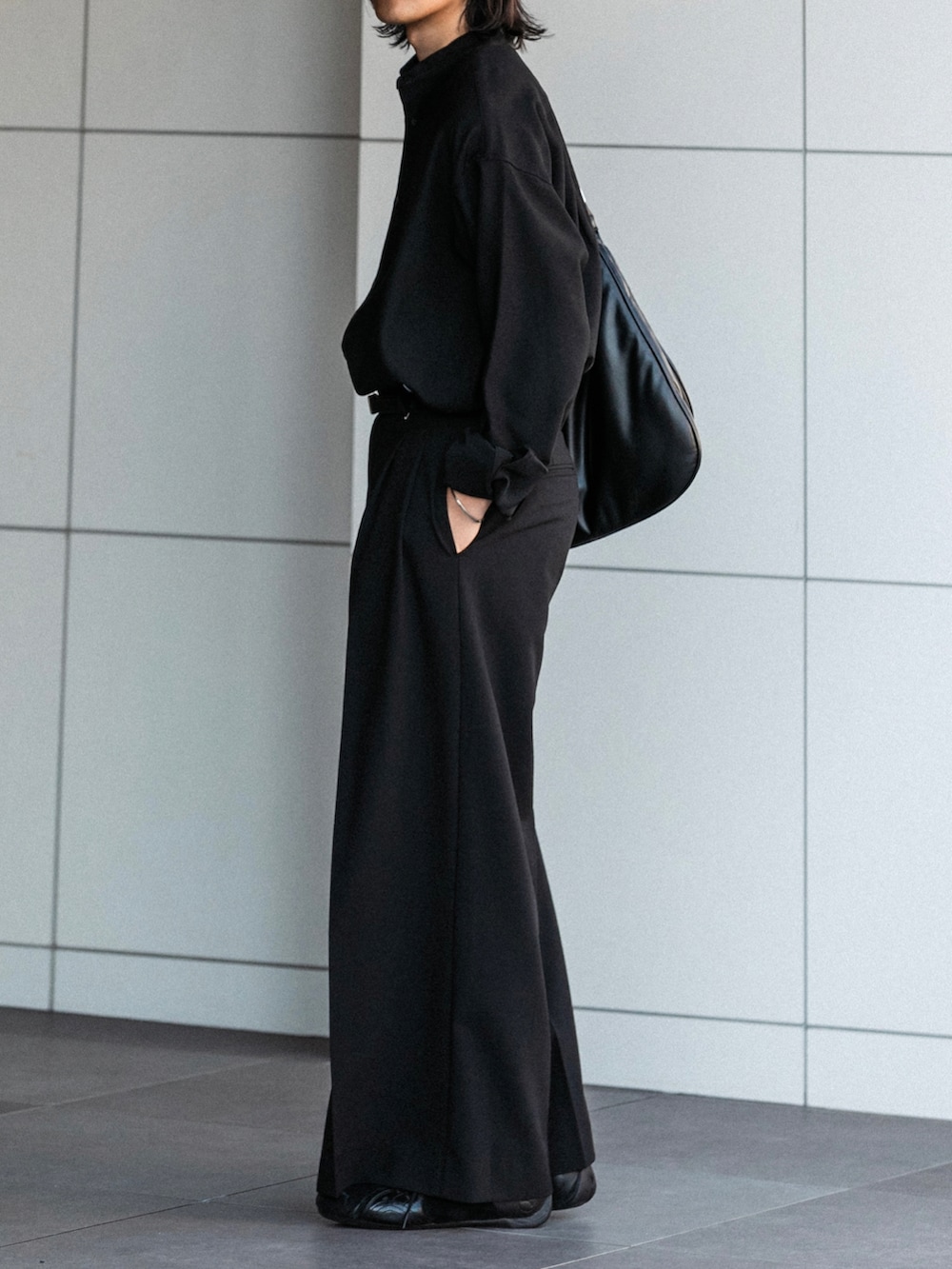 ブラック系のスラックス、ブラック系のシャツ/ブラウス、ブラック系のショルダーバッグを着用したメンズの秋コーディネートの3枚目の写真