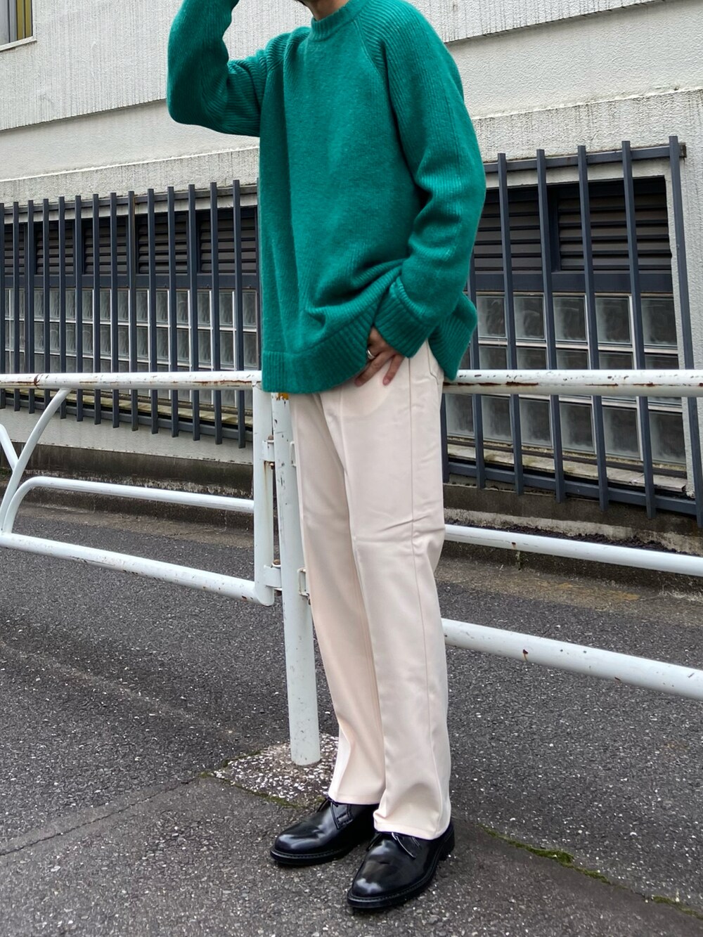 ベージュ系のスラックス、ブラック系のドレスシューズ、グリーン系のニット/セーターを着用したメンズの秋コーディネートの2枚目の写真