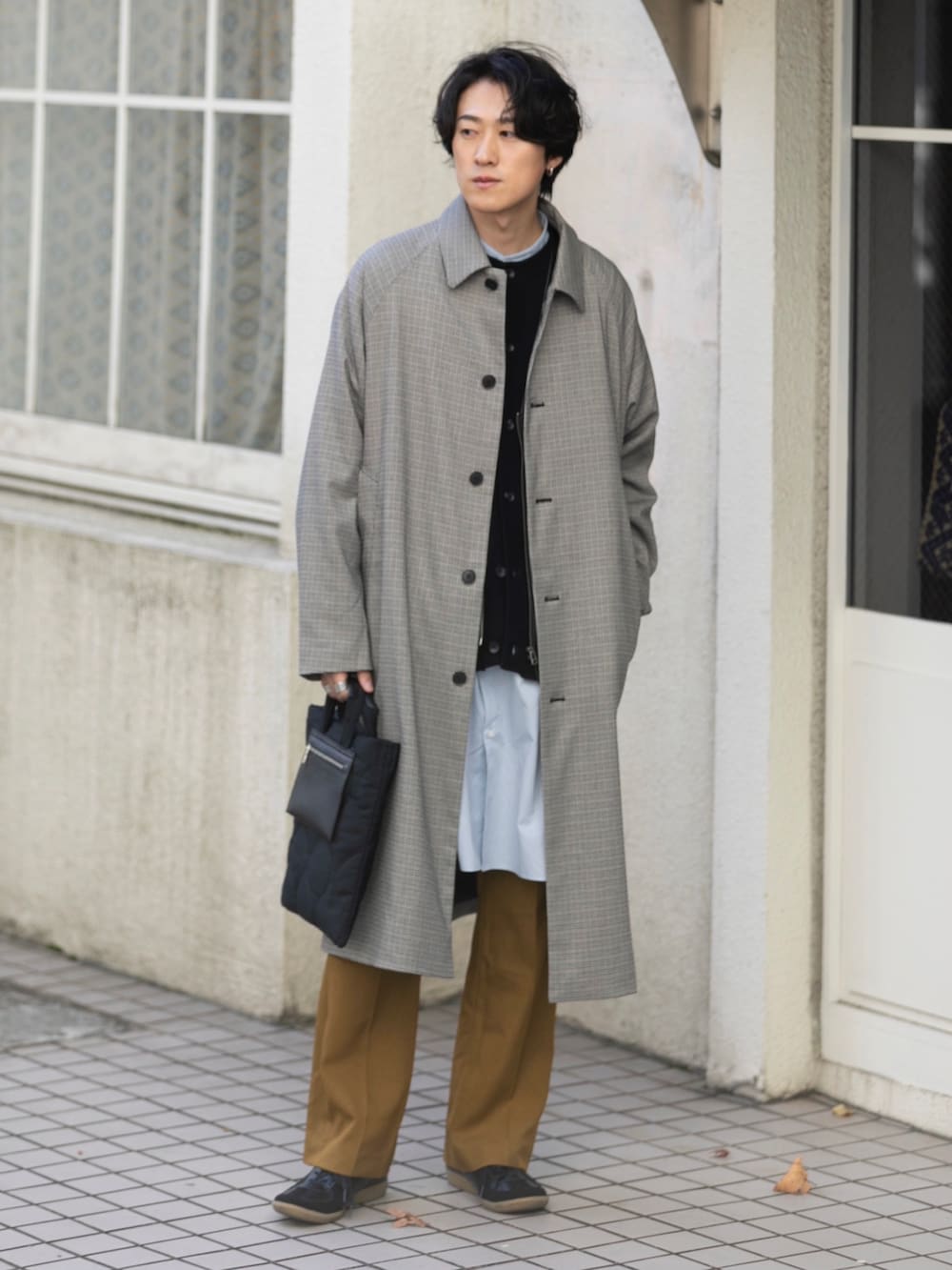 ブラック系のトートバッグ、ベージュ系のステンカラーコート、ブラック系のスニーカーを着用したメンズの冬コーディネートの2枚目の写真