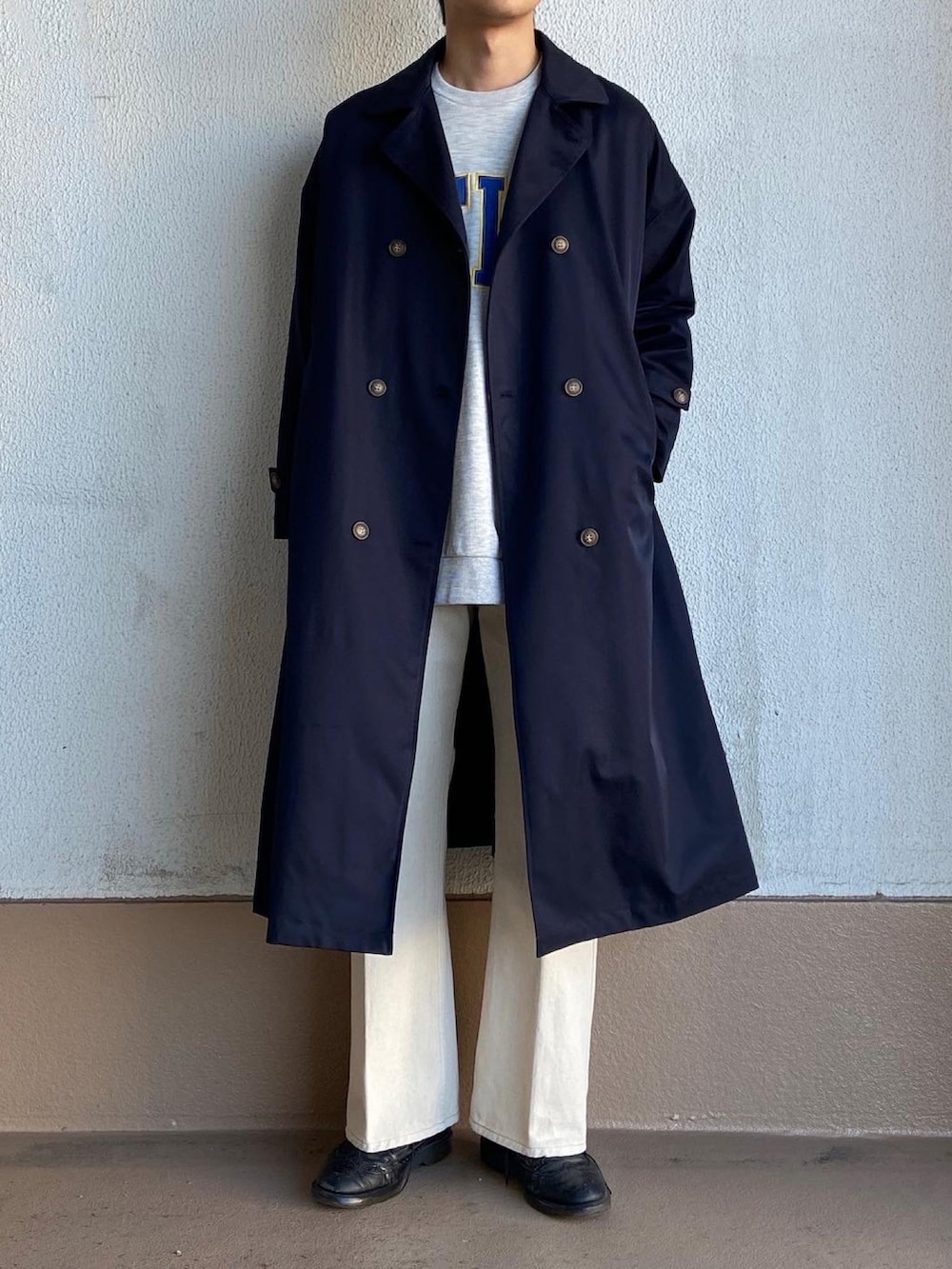 グレー系のスウェット、ホワイト系のデニムパンツ、ブルー系のステンカラーコートを着用したメンズの春コーディネートの2枚目の写真