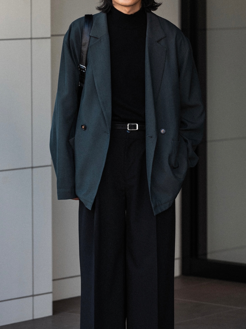 ブラック系のニット/セーター、ブラック系のスラックス、グレー系のその他アウターを着用したメンズの秋コーディネートの3枚目の写真